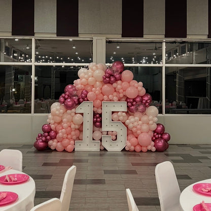 Decorative setup with balloons and '15' for a special event in a room with large windows.