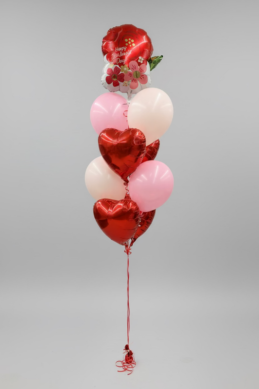 Heart-shaped balloons in red and pink against a store card display background