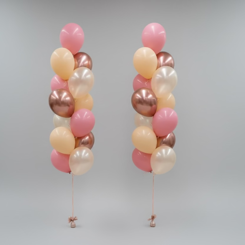 Three balloon columns in pink, gold, and bronze on a plain background