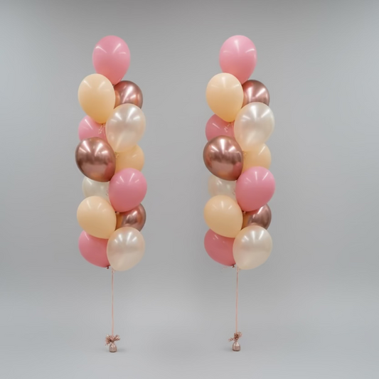 Three balloon columns in pink, gold, and bronze on a plain background